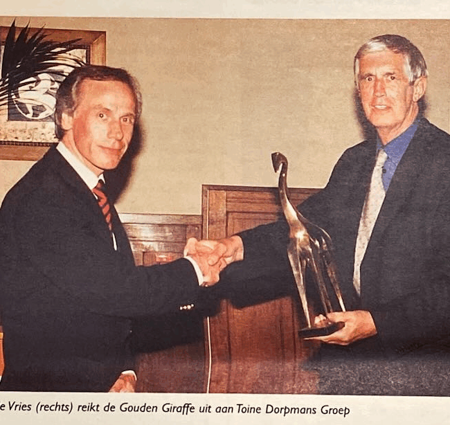 Twee mannen met gouden giraffe prijs